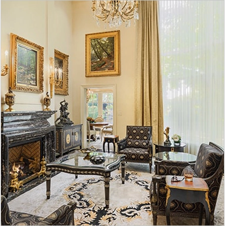 A living room with two chairs, a fireplace and a rug.