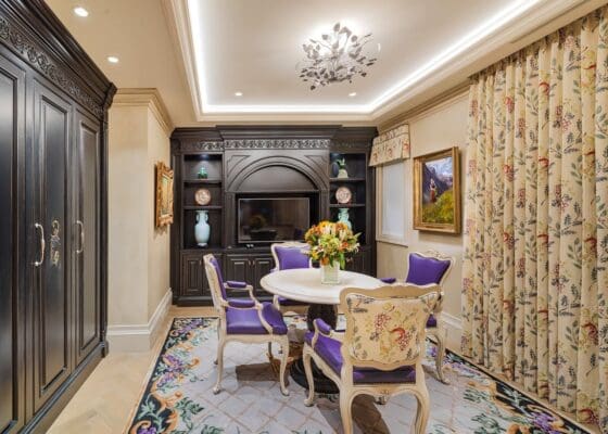 A dining room with purple chairs and a fireplace.