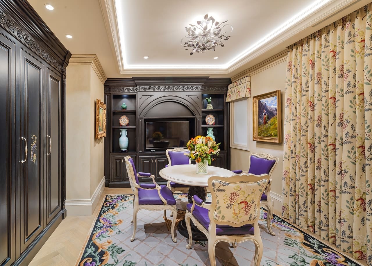 A dining room with purple chairs and a fireplace.