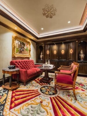 A living room with red furniture and a large painting.