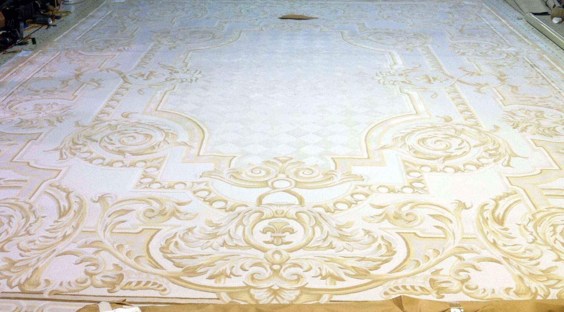 A white and gold floor covering with an ornate design.