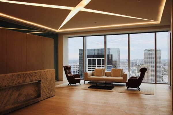 A living room with large windows and a fireplace.