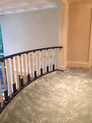 A curved stair case with metal and wood railing.