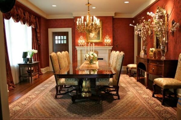 A dining room with a table and chairs, fireplace and chandelier.