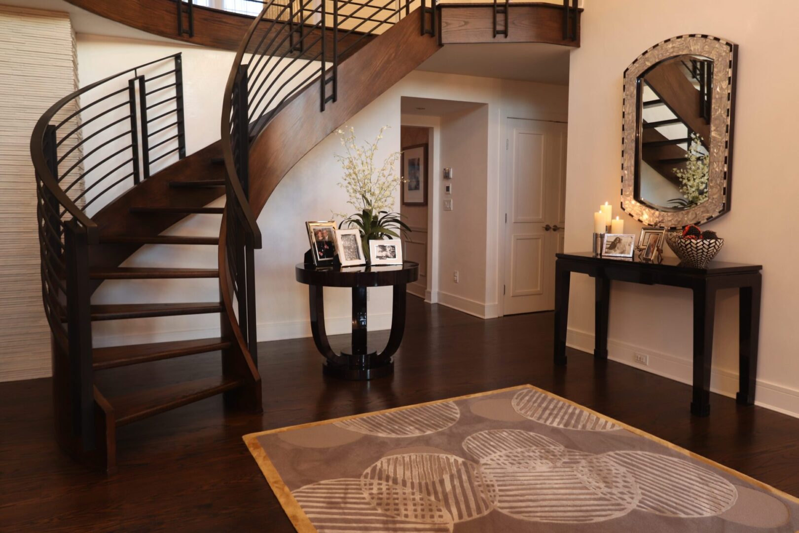 A rug in front of the stairs and mirror