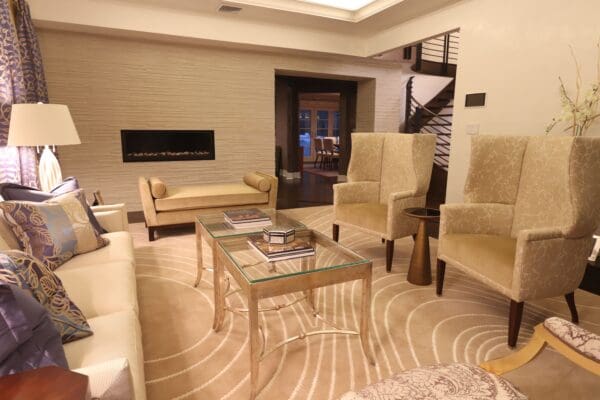 A living room with beige furniture and a fireplace.