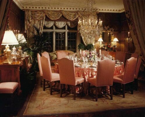 A dining room with pink chairs and table