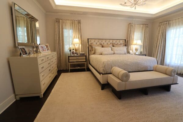 A bedroom with a large bed and white carpet.